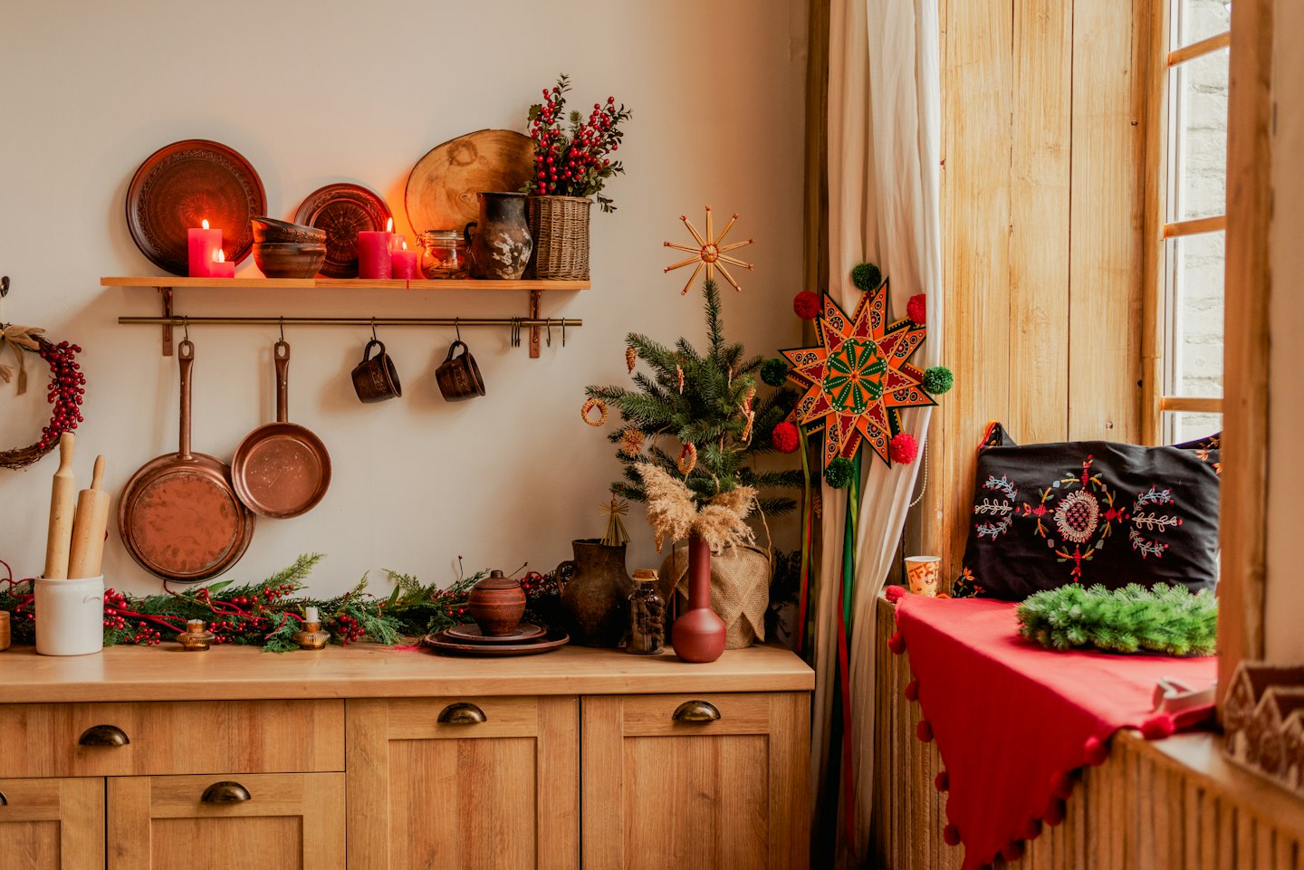 Festliche Küche mit Weihnachtsbaum und Kerzenlicht.